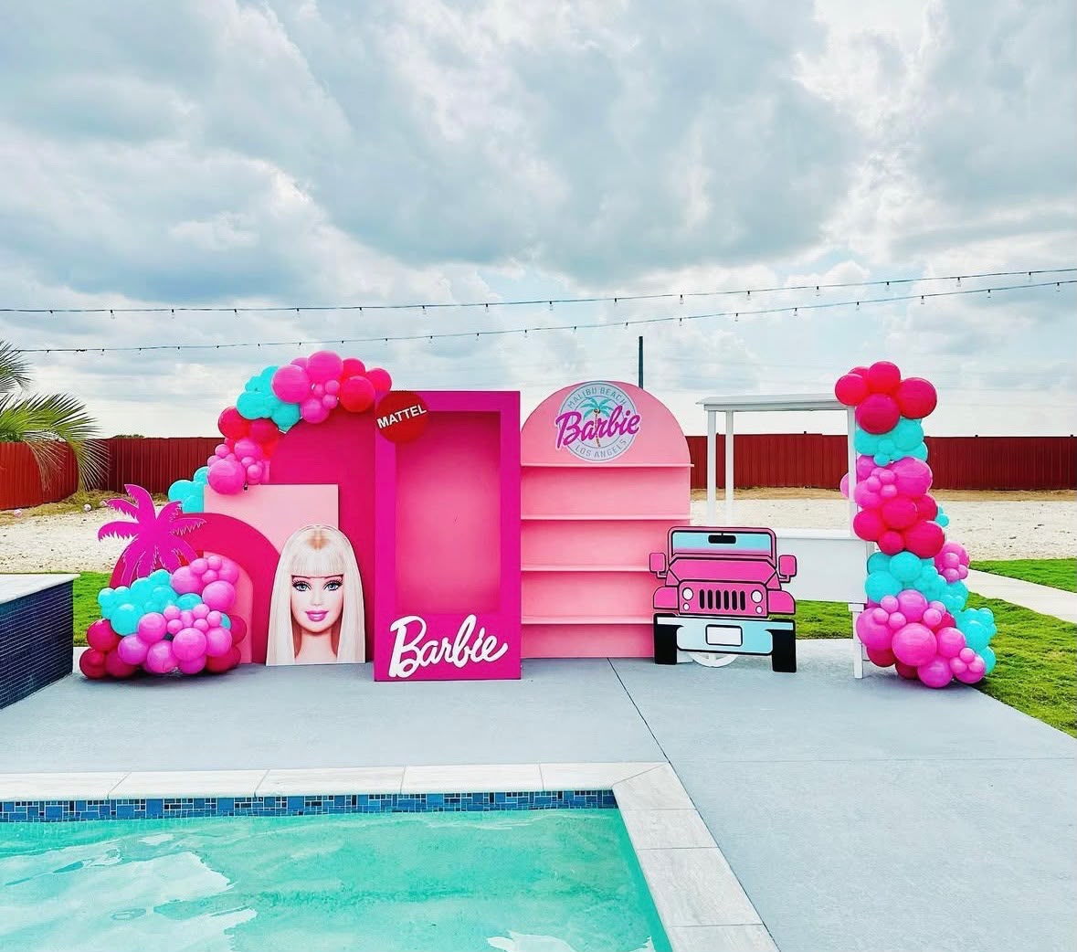 Pink and turquoise Barbie themed poolside backdrop with balloon garland by LUX Event Design